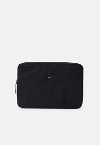 Mala para laptop em nylon preto com superfície texturizada, fecho com zíper, detalhe de costura angular e pequeno logo da Nike em prata na parte da frente.