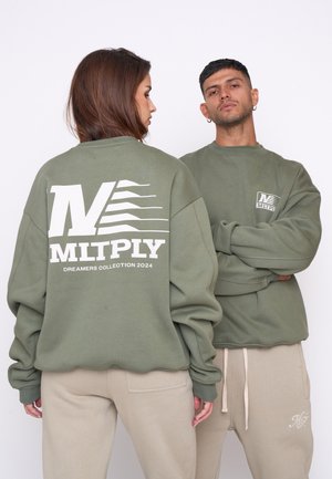 Sweatshirts vert olive avec de grands logos blancs sur le dos et à l'avant, associés à un pantalon beige ; coupe décontractée et poignets côtelés.