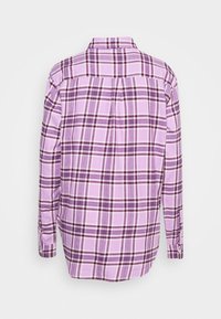 Chemise à manches longues boutonnée avec un motif à carreaux violets et roses, vue de dos sur un fond blanc uni.