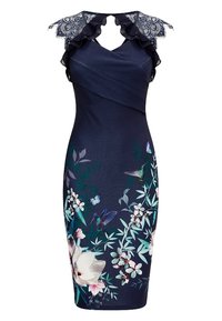 Robe bleu marine longueur genou avec épaules en dentelle, finition volants, imprimé floral et colibri sur la jupe, et détail en croix au niveau du buste.