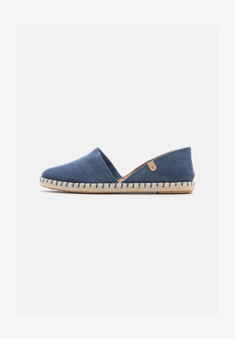 Chaussure plate espadrille en daim bleu avec semelle naturelle en corde tressée et petite étiquette de marque marron clair sur le dessus.