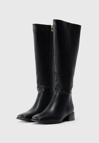 Bottes noires montant jusqu'au genou en cuir lisse, avec une fermeture éclair latérale, un petit talon bloc et un design à bout arrondi.