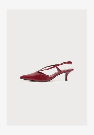 Zapato de tacón slingback rojo con punta afilada, finas tiras cruzadas y hebilla pequeña, tacón bajo tipo kitten y acabado en cuero liso, vista lateral.
