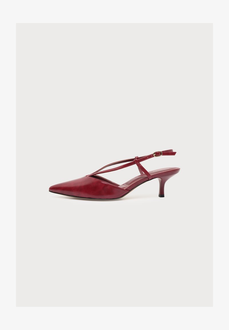 Escarpin slingback rouge à bout pointu avec fines brides croisées et petite boucle, petit talon kitten et finition cuir lisse, vue latérale.