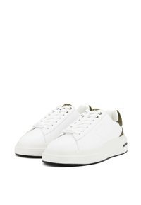 Sneakers bianchi con un upper in pelle liscia, accenti in suede olivastro a contrasto, suola in gomma spessa e lacci rotondi. Design visivamente pulito.