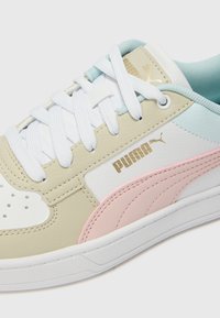 Sneakers met een bovenwerk van wit, beige en roze leer, met een lichtblauwe accentkleur, witte veters en een gouden logo aan de zijkant.
