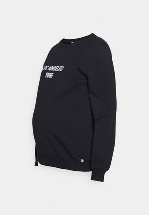 Sweat-shirt noir avec le texte blanc « LOS ANGELES 1985 ». Comprend un col rond, des manches longues et un bouton argenté en accent sur l'ourlet.