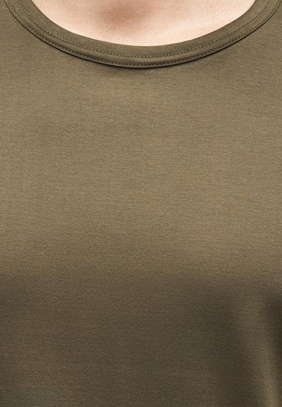 Κοντινή λήψη υφάσματος ελιάς με εμφανές στρογγυλό λαιμόκοψη και λεπτομέρεια ραφής σε ένδυμα.