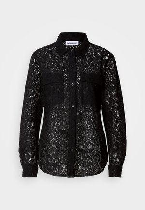 Chemise noire en dentelle avec deux poches avant, col, manches longues et motif floral texturé sur l'ensemble.