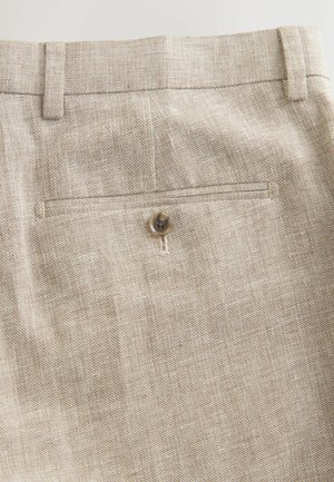 Liibese beežid püksid, millel on sile tekstuur, slim-fit lõige ja taga tasku, millel on pruun nööbi detail.