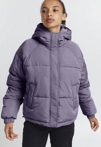 Giacca imbottita viola con colletto alto, cappuccio e zip sicura, dotata di ampie tasche frontali e polsini elasticizzati.