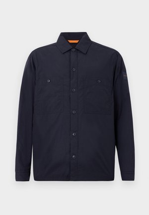 Navy blue long-sleeve button-up shirt with two chest pockets and a collar, featuring a small logo patch on the left sleeve.