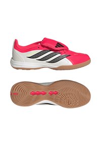 Κόκκινο και λευκό εσωτερικό αθλητικό παπούτσι Adidas με μαύρες ρίγες, λουράκι με βέλκρο και σόλα από καουτσούκ, εμφανιζόμενο από πλευρική και κάτω όψη.