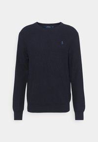 Marinblå crewneck sweatshirt tillverkad av texturerat stickat tyg, med en liten broderad logotyp på bröstet samt ribbade muddar och nederkant.