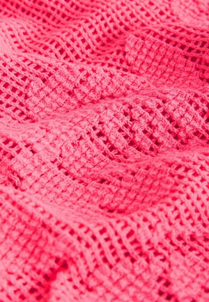 Růžová pletená látka s texturovaným vzorem otevřené vazby, která kombinuje diamanty a čtverce v měkkém, lehkém materiálu.