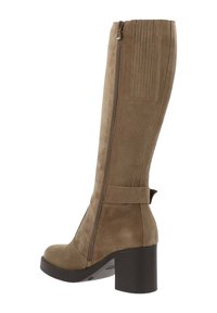 Hoge bruine suède laarzen met een zijrits, ronde neus, chunky zwarte hak en een decoratieve strap detail bij de enkel.
