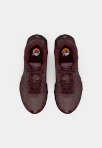 Bordowe buty sportowe z teksturowaną powierzchnią, wyraźną podeszwą i czarnymi akcentami. Cechuje je wyraźne logo Air Max na wkładce.