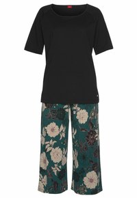 Black short-sleeve top with a square neckline paired with teal floral wide-leg pants featuring large white and black flowers.