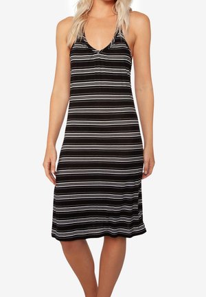 Vrouw met een zwart-wit horizontaal gestreepte mouwloze midijurk met een V-hals en spaghettibandjes.