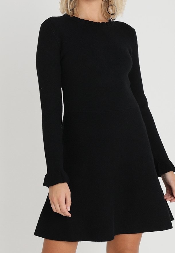 Abito nero in maglia con corpino aderente, gonna a campana, scollatura ondulata e maniche a campana. Tessuto morbido, design minimalista.