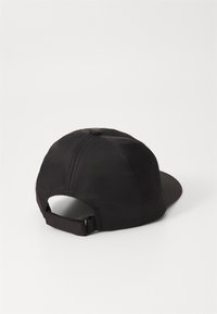 Gorra de béisbol negra hecha de tela con una textura suave. Cuenta con una visera curva y una correa ajustable en la parte posterior. Diseño simple y sin adornos.