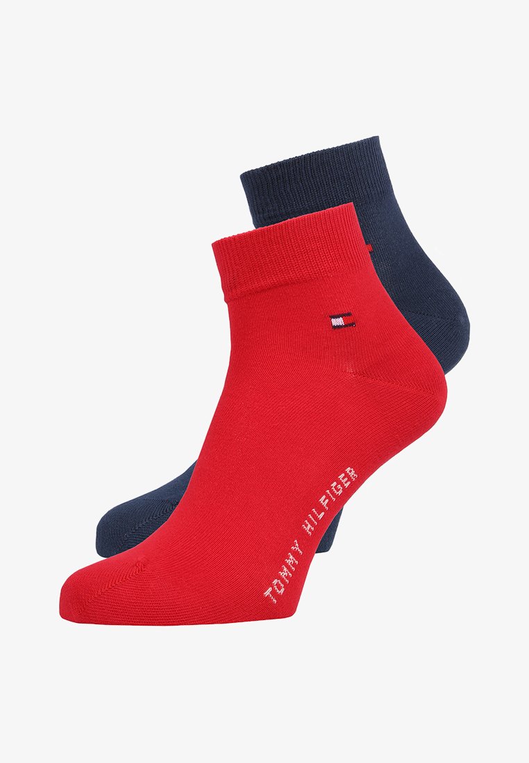 Dois pares de meias de tornozelo: um em vermelho sólido com o logótipo da Tommy Hilfiger e outro em azul marinho sólido, ambos reforçados nas bordas.