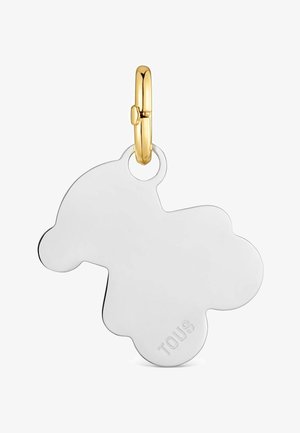 Colgante de plata con forma de oso y la inscripción "TOUS", unido a un pequeño cierre dorado.