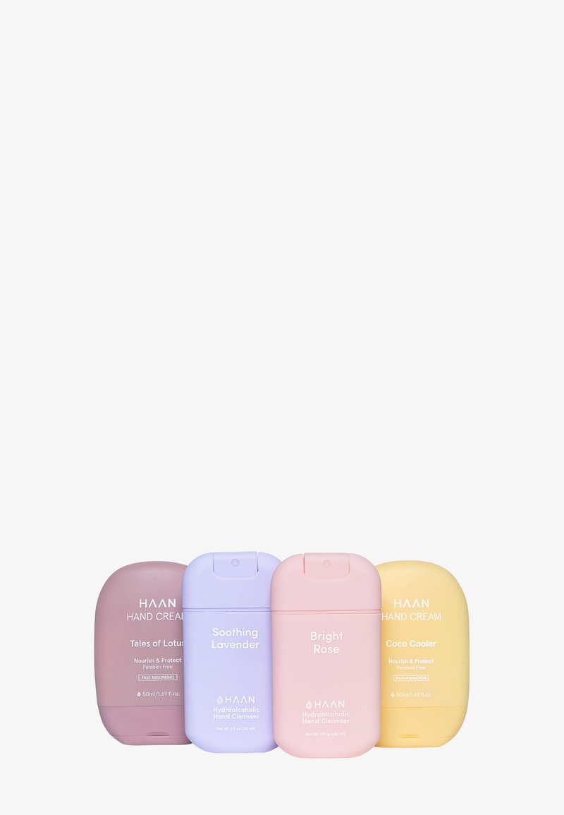 Quatre contenants de crème pour les mains et de nettoyant dans des couleurs pastel : rose, lavande, violet et jaune, avec des bords arrondis et des étiquettes en texte blanc.