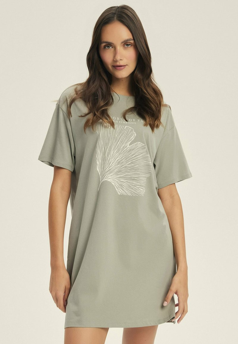 Jasnozielona sukienka w kształcie T-shirtu z miękkiego materiału, z krótkimi rękawami i białym graficznym wzorem liścia z przodu.