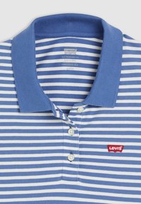 Μπλε και άσπρη ριγέ πόλο μπλούζα με ραμμένο γιακά και τρία κουμπιά. Διαθέτει κόκκινο λογότυπο Levi's στην αριστερή πλευρά. Απαλή υφασμάτινη σύνθεση.