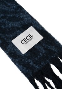 Mørkeblå tørklæde i et blødt, tekstureret stof med frynsede kanter. Det har et hvidt mærke med "CEcil" og "ACCESSORIES" trykt med sort.