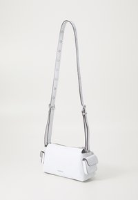 Biely kožený crossbody bag so smooth textúrou, nastaviteľným popruhom so striebornými prvkami a malým predným vreckom.