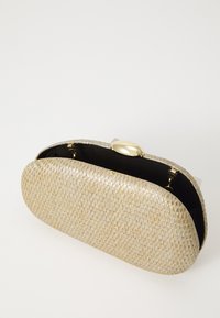 Bolso de mano ovalado en tono dorado tejido con forro interior negro y un cierre dorado brillante, mostrado abierto sobre un fondo blanco.