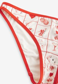 Spodný diel bikín s červeným lemovaním má krémový základ s opakujúcim sa grafickým vzorom srdiečok, nápojov a hravých ilustrácií.