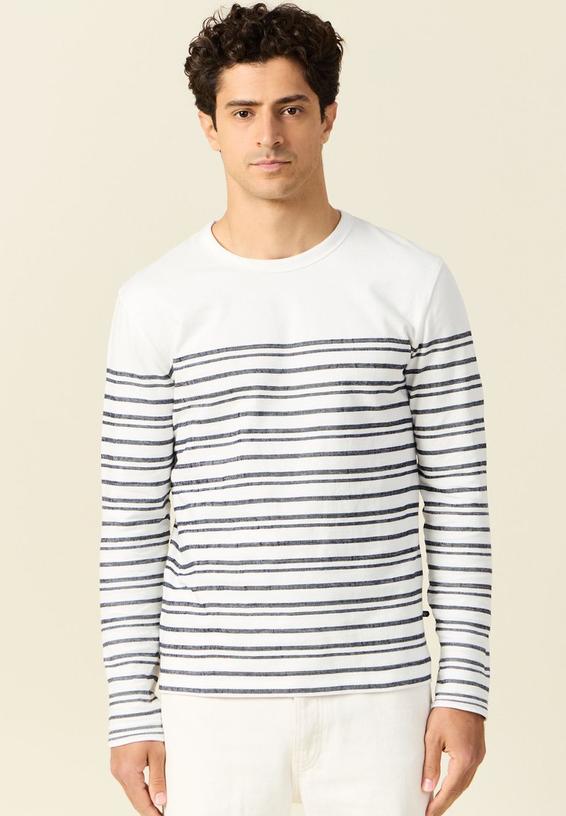 Langarmshirt met een witte body en marineblauwe horizontale strepen, voorzien van een ronde hals en een rechte zoom. Zacht materiaal, casual ontwerp.