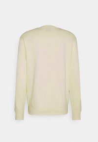 Sudadera amarilla clara con mangas largas, cuello redondo y puños de canalé. Fabricada con material suave, que presenta una textura lisa.