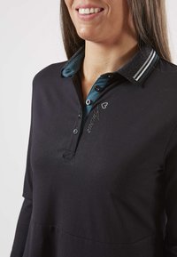 Polo shirt noir à manches longues avec un col turquoise, doté de trois boutons, de rayures blanches et teal sur le col, et d'un détail brodé.
