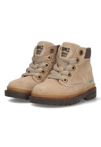 Stivaletti alla caviglia in suede beige con dettagli marroni, occhielli in metallo e lacci testurizzati. Suola in gomma con intersuola marrone e dettagli blu.