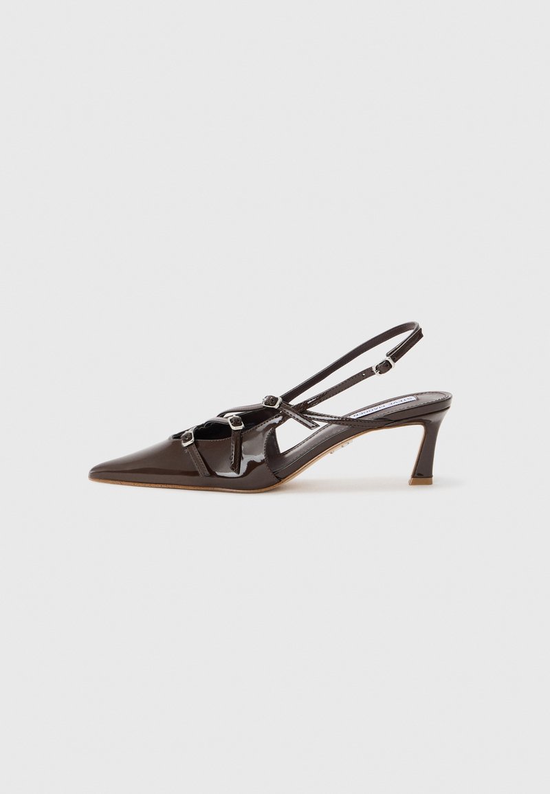 Tacco slingback in pelle verniciata marrone con punta affusolata, cinturini regolabili e fibbie decorative sul davanti. Altezza del tacco di 3 pollici.