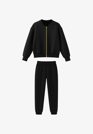 Completo felpa e pantaloni neri, realizzato in tessuto morbido. La felpa ha una cerniera dorata e un collo rotondo; i pantaloni hanno un elastico in vita.