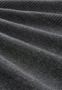 Grijze textiel met een zachte, harige textuur, met subtiele golven en een licht gemêleerd patroon over het oppervlak.