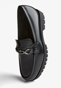 Fekete bőr loaferek textúrált mintázattal, fonott ezüst díszítéssel és masszív gumitalppal a jobb tapadás érdekében.