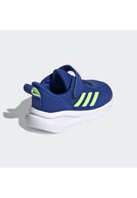 Scarpa da ginnastica blu navy con tomaia in rete testurizzata, dettagli verde neon e suola bianca. Presenta una fascetta in velcro e un tab di trazione sul tallone.