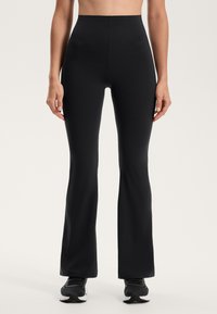 Fekete, bővülő leggings rugalmas anyagból, magas derékkal. Simás textúra és minimalista dizájn, látható logók nélkül.
