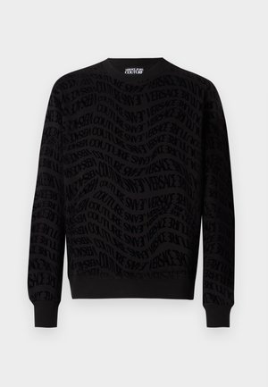Sweatshirt noir avec un motif texturé comportant un logo répété. Manches longues, col rond, et poignets et ourlet côtelés.