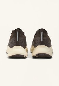 Bruine gebreide sportieve schoenen met een gewatteerde kraag, rubberen zool en reflecterende accenten op de hiel. Textuur met een gestroomlijnd ontwerp.