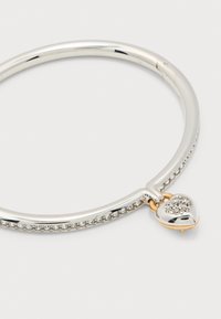 Ασημένιο βραχιόλι με κρύσταλλα ενσωματωμένα και ένα μικρό ασημένιο μενταγιόν καρδιά διακοσμημένο με κρύσταλλα και μια χρυσή θηλιά.