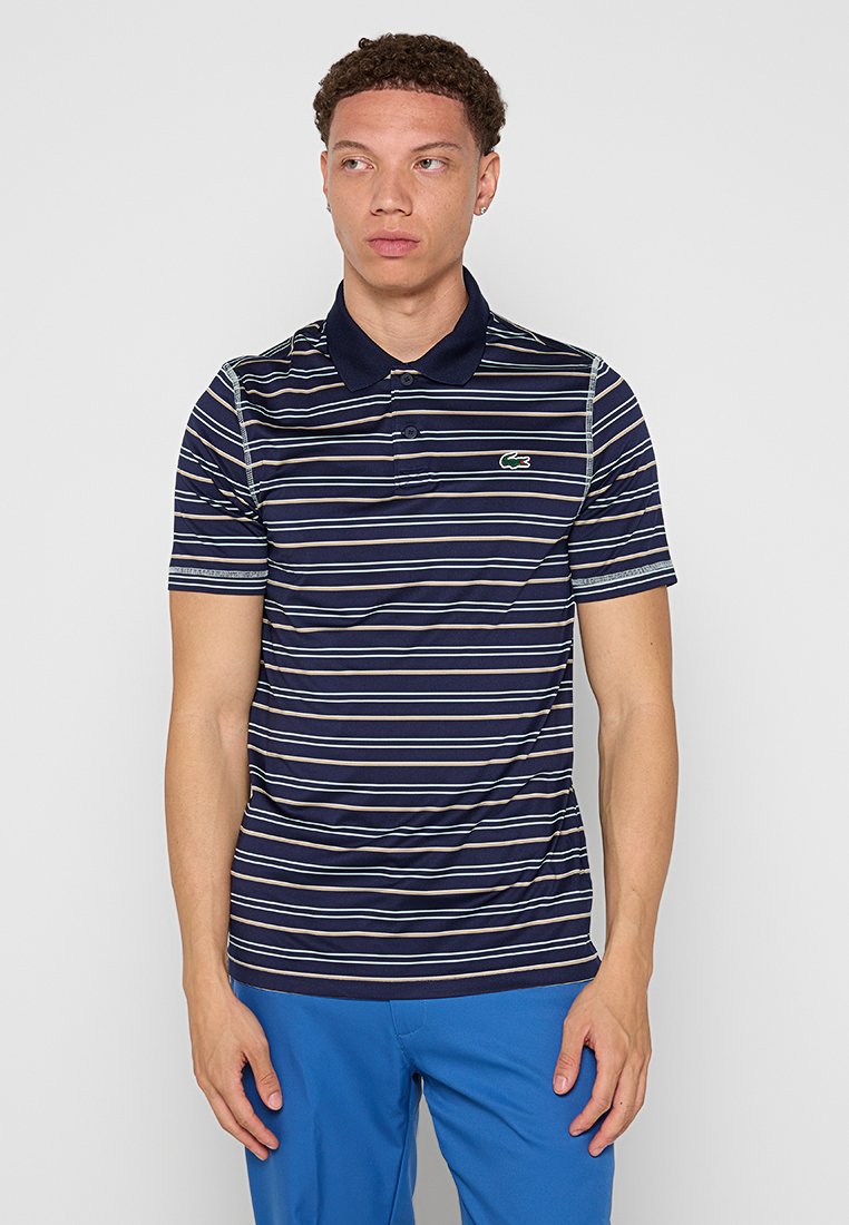 Polo rayé marin à manches courtes, présentant de fines rayures blanches et vertes, un col et un petit logo vert sur la poitrine.