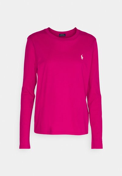 Hosszú ujjú, élénk rózsaszín pamut póló, kerek nyakkivágással és kis fehér polo logóval a bal mellen. Sima textúra és klasszikus fazon.