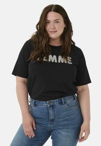 Black cotton t-shirt with "GIMME" in silver glitter lettering. Paired with high-waisted blue denim jeans, featuring a classic design.